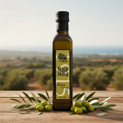 Taris Riviera olīveļļa 250ml stikla pudelē ar svaigām zaļām olīvām un olīvu zariem uz koka virsmas