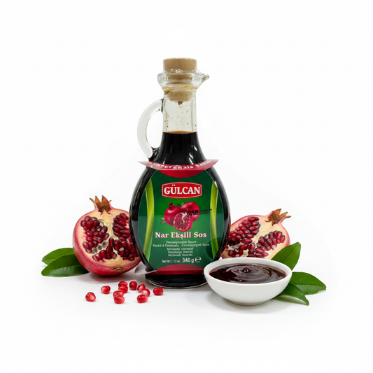 Gulcan granātābolu mērce stikla pudelē 340g, minimālistisks produkta foto ar svaigiem granātāboliem un lapām, balts fons