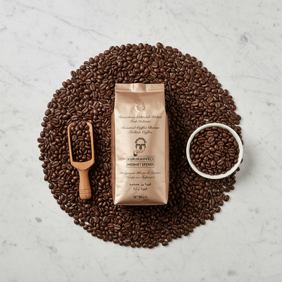 Kafijas pupiņas KURUKAHVECI MEHMET EFENDI 500g elegantā flat lay kompozīcijā ar 100% Arabica pupiņām